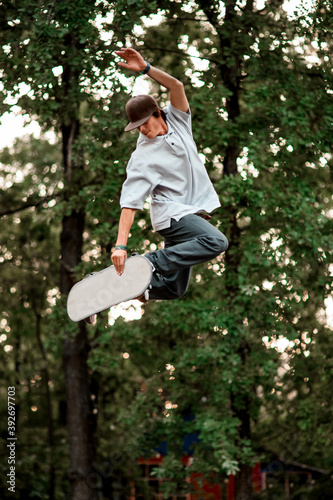 Cuadro en lienzo guy in cap and with skateboard simulator jumping up against the backdrop of gree