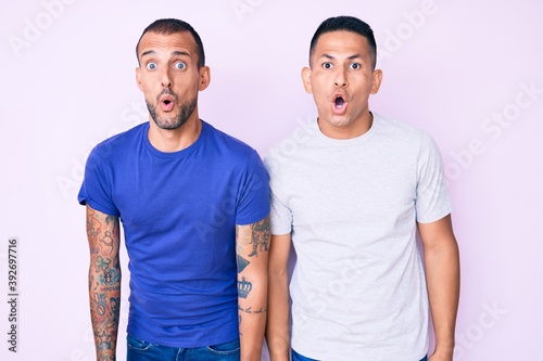 Young gay couple of two men wearing casual clothes scared and amazed with open mouth for surprise, disbelief face