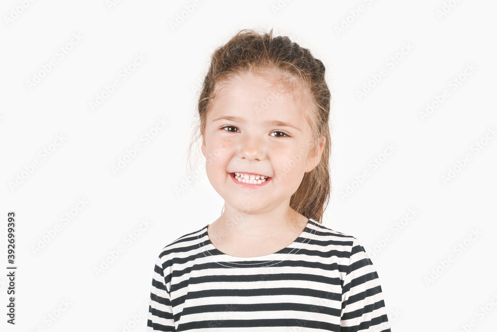 Cute smiling girl looking at camera. Posing little girl wearing striped shirt. Cute smiling girl looking at camera. Posing little girl wearing striped shirt.