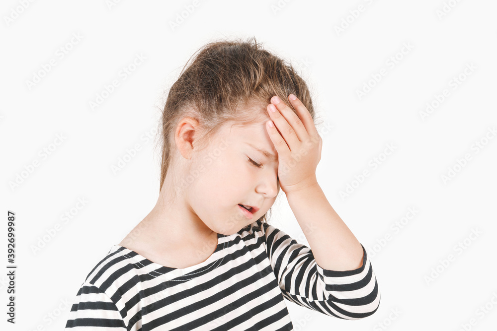 Facepalm. Upset girl with closed eyes and hand holding on her forehead. Frustrated forgetful girl with head tilted forward down. Posing a little girl wearing a striped shirt. Isolated background. Facepalm. Upset girl with closed eyes and hand holding on her forehead. Frustrated forgetful girl with head tilted forward down. Posing a little girl wearing a striped shirt. Isolated background.