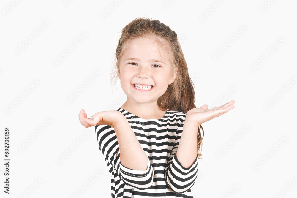 Cute laughing girl looking at camera. Happy girl with wide smile and hands up shouting Surprise, Win. Posing little girl wearing striped shirt. Celebrating concept. Cute laughing girl looking at camera. Happy girl with wide smile and hands up shouting Surprise, Win. Posing little girl wearing striped shirt. Celebrating concept.
