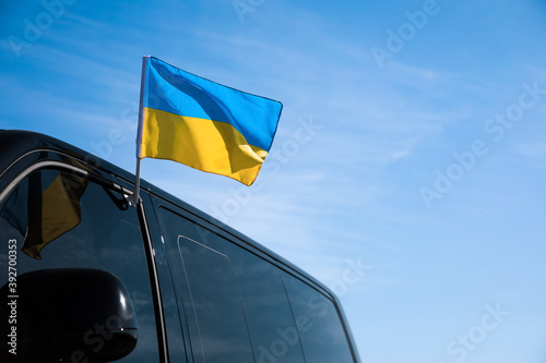 National flag of Ukraine on car window outdoors. Space for text photo