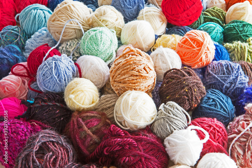 A bundle of balls of yarn of varying colors, size, texture and type. 