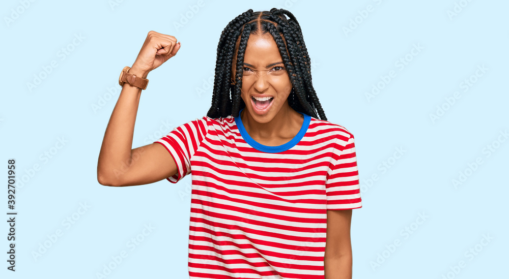 Beautiful hispanic woman wearing casual clothes angry and mad raising fist frustrated and furious while shouting with anger. rage and aggressive concept. Beautiful hispanic woman wearing casual clothes angry and mad raising fist frustrated and furious while shouting with anger. rage and aggressive concept.