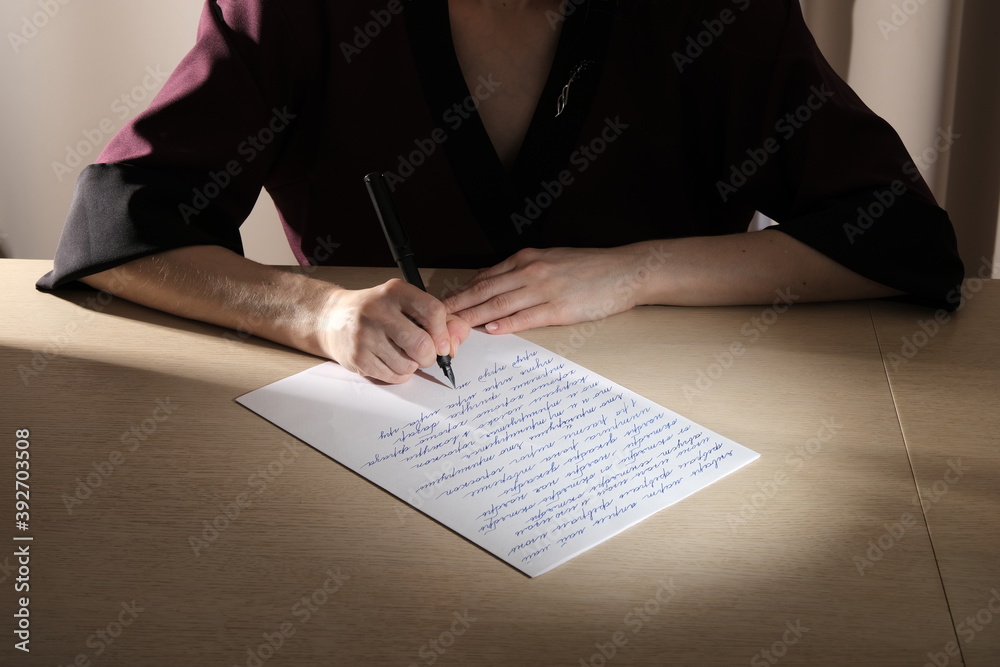 The girl is engaged in calligraphy at the table The girl is engaged in calligraphy at the table