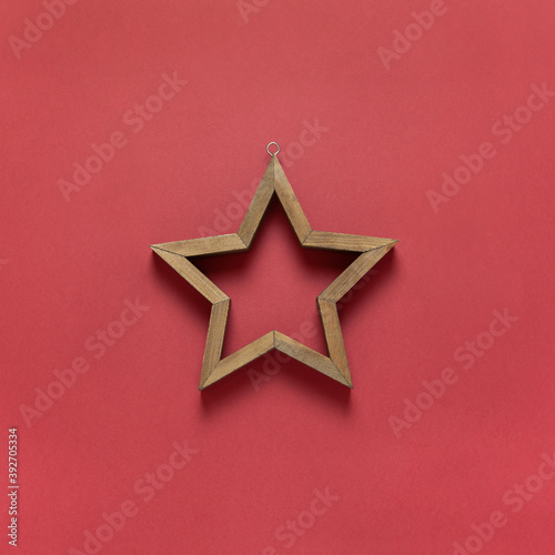 Wallpaper Mural Christmas toy wooden hollow star on dark red background. Festive, New Year concept. Square format, flat lay. Minimal style. Top view Torontodigital.ca