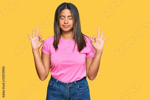 Young latin girl wearing casual clothes relax and smiling with eyes closed doing meditation gesture with fingers. yoga concept.