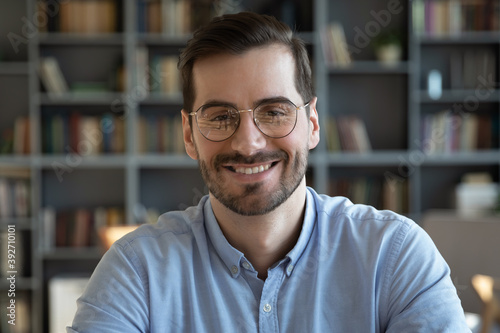 Head shot of young businessman smile look at camera. Concept of video call negotiations with clients partners, hiring online, human resource, teacher, business trainer successful entrepreneur portrait