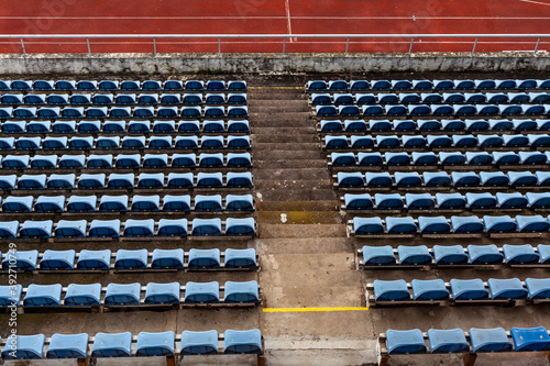 empty auditorium in athletic stadium, rows of blue chairs
