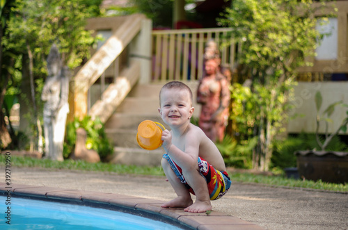 a little boy plays by the pool in a tropical country. Summer vacation, family, lifestyle