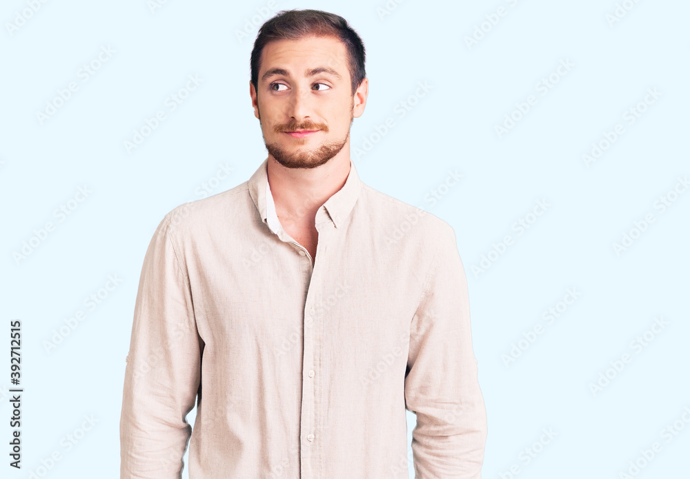 Young handsome caucasian man wearing casual clothes smiling looking to the side and staring away thinking. Young handsome caucasian man wearing casual clothes smiling looking to the side and staring away thinking.