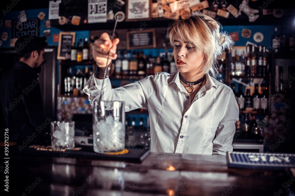 Girl bartender concocts a cocktail at the public house