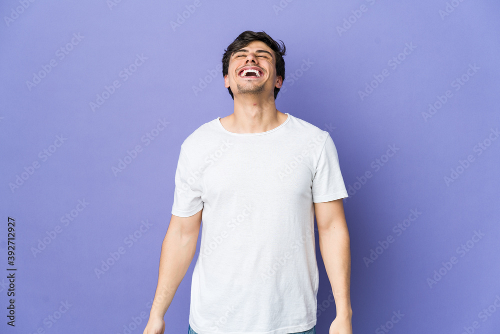 Young cool man relaxed and happy laughing, neck stretched showing teeth. Young cool man relaxed and happy laughing, neck stretched showing teeth.