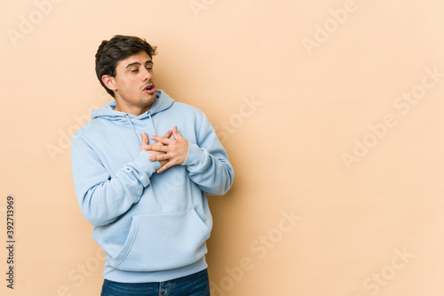 Young cool man has friendly expression, pressing palm to chest. Love concept.