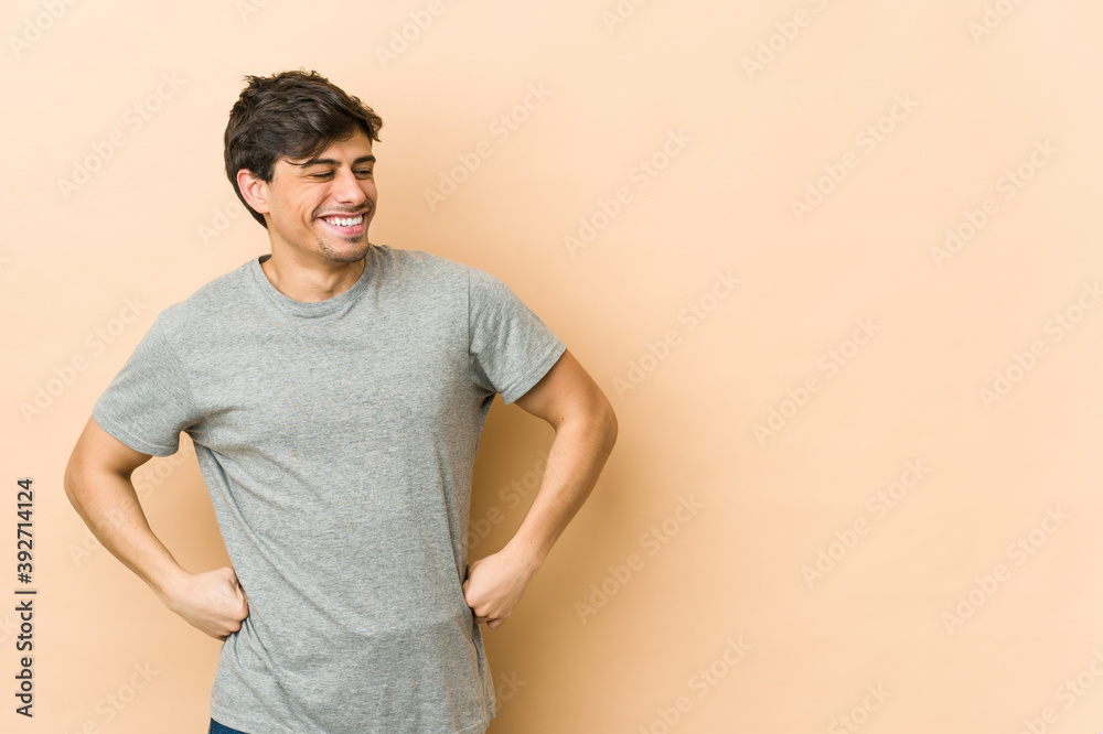 Young cool man laughs happily and has fun keeping hands on stomach. Young cool man laughs happily and has fun keeping hands on stomach.