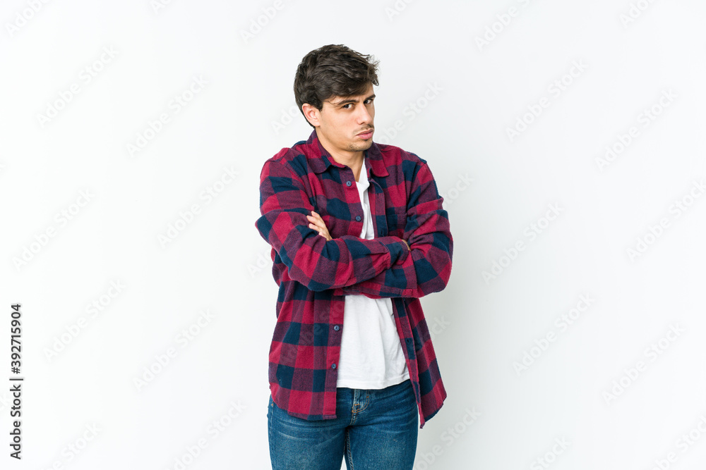 Fototapeta premium Young cool man frowning face in displeasure, keeps arms folded.