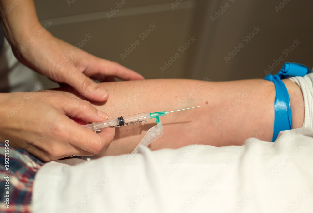 Female doctor and nurse working with patiens in a private area due to coronavirus. Covid 19 vaccine. Syiringe and vaccinetion.