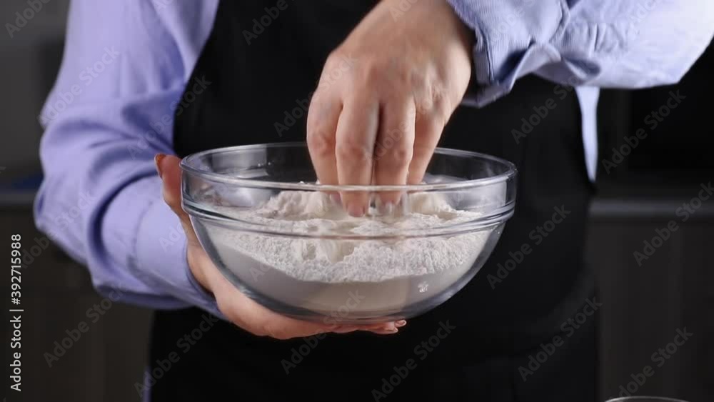 female chef holding glass bowl with white flour in her hand
female chef holding glass bowl with white flour in her hand