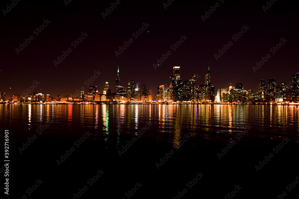 Chicago city skyline reflecting off the water at night Chicago city skyline reflecting off the water at night