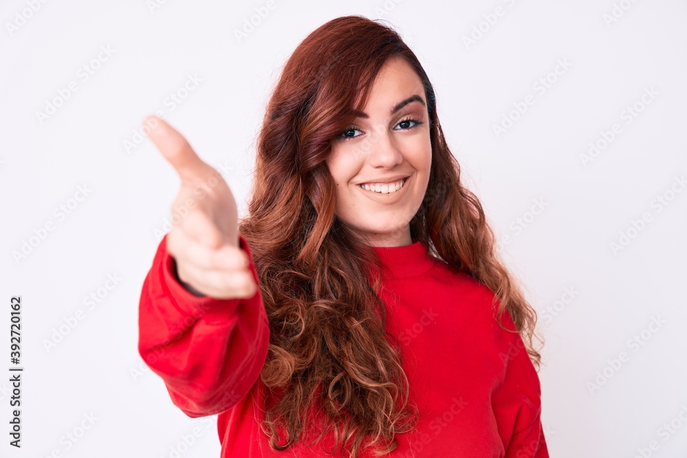 Young beautiful woman wearing casual clothes smiling friendly offering handshake as greeting and welcoming. successful business. Young beautiful woman wearing casual clothes smiling friendly offering handshake as greeting and welcoming. successful business.