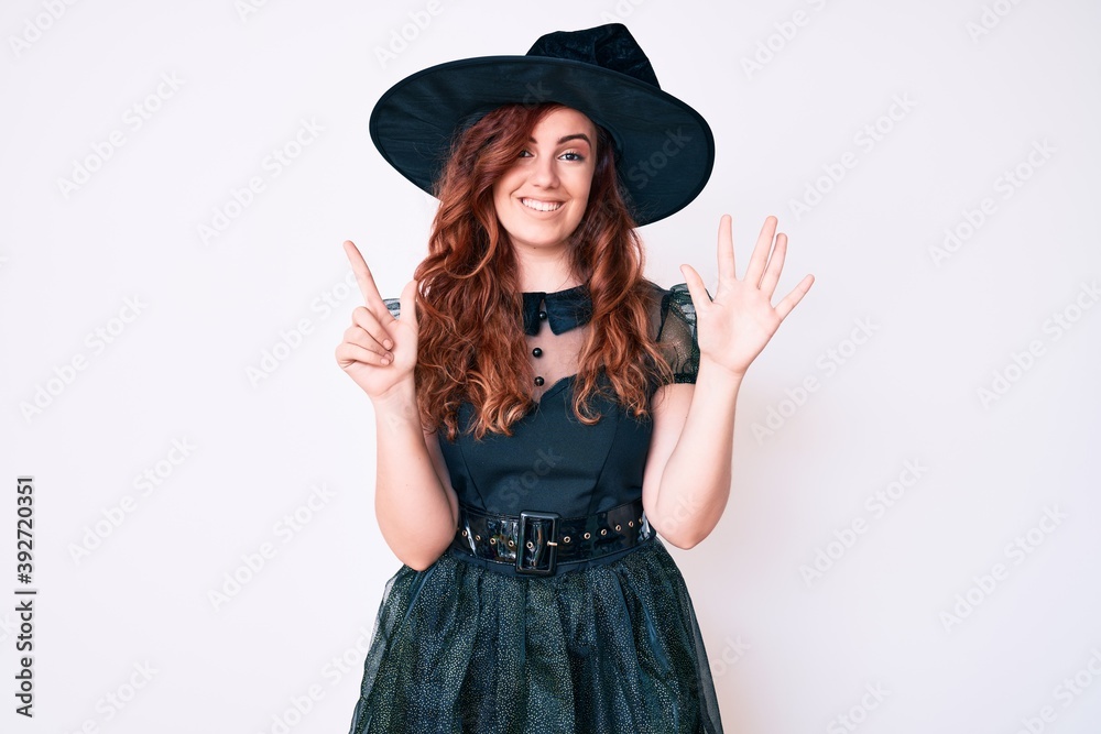 Young beautiful woman wearing witch halloween costume showing and pointing up with fingers number seven while smiling confident and happy. Young beautiful woman wearing witch halloween costume showing and pointing up with fingers number seven while smiling confident and happy.