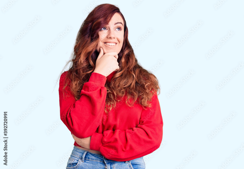 Young beautiful woman wearing casual winter sweater with hand on chin thinking about question, pensive expression. smiling with thoughtful face. doubt concept. Young beautiful woman wearing casual winter sweater with hand on chin thinking about question, pensive expression. smiling with thoughtful face. doubt concept.