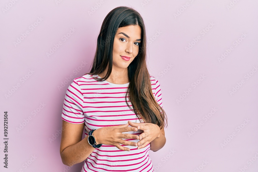 Young brunette woman wearing casual clothes over pink background hands together and fingers crossed smiling relaxed and cheerful. success and optimistic Young brunette woman wearing casual clothes over pink background hands together and fingers crossed smiling relaxed and cheerful. success and optimistic