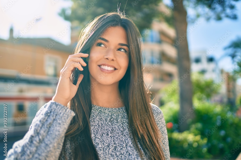 Young beautiful hispanic girl smiling happy talking on the smartphone at the city.