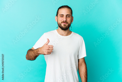 Young man with long hair look smiling and raising thumb up