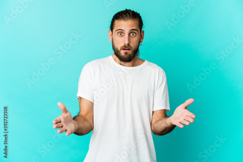 Young man with long hair look surprised and shocked.