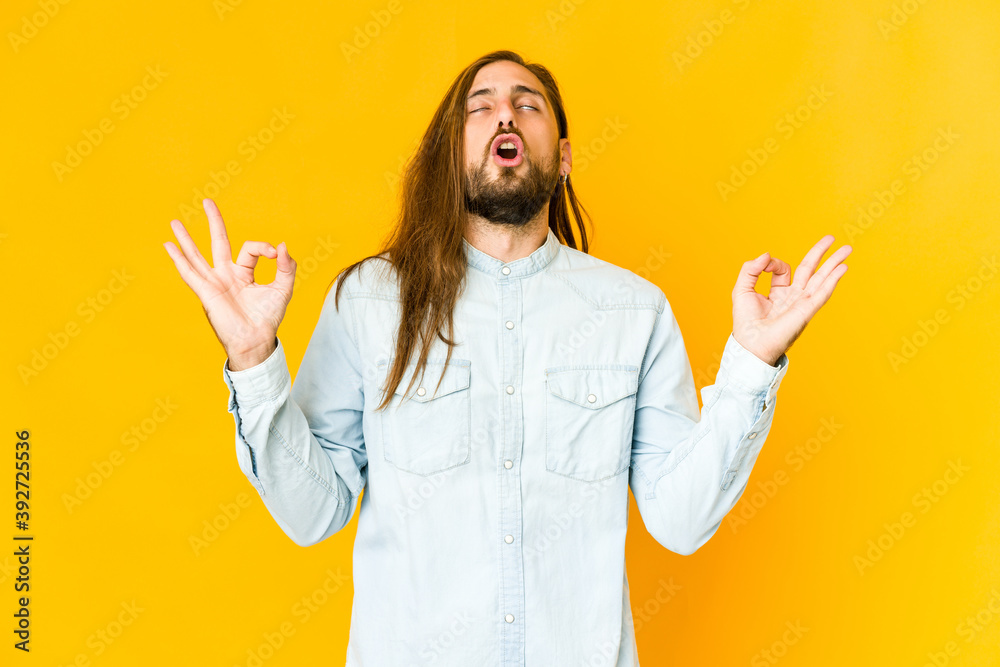 Young man with long hair look relaxes after hard working day, she is performing yoga. Young man with long hair look relaxes after hard working day, she is performing yoga.