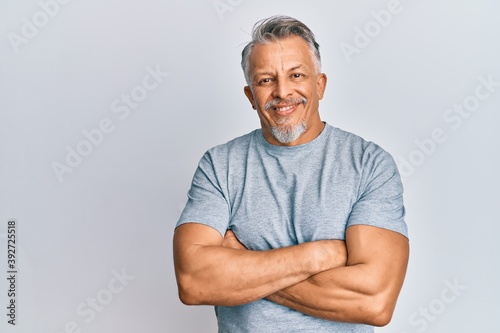 Middle age grey-haired man wearing casual clothes happy face smiling with crossed arms looking at the camera. positive person.