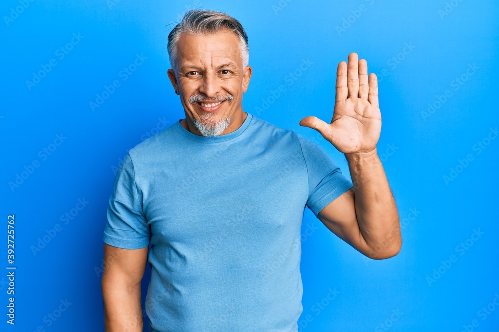Middle age grey-haired man wearing casual clothes showing and pointing up with fingers number five while smiling confident and happy. Middle age grey-haired man wearing casual clothes showing and pointing up with fingers number five while smiling confident and happy.