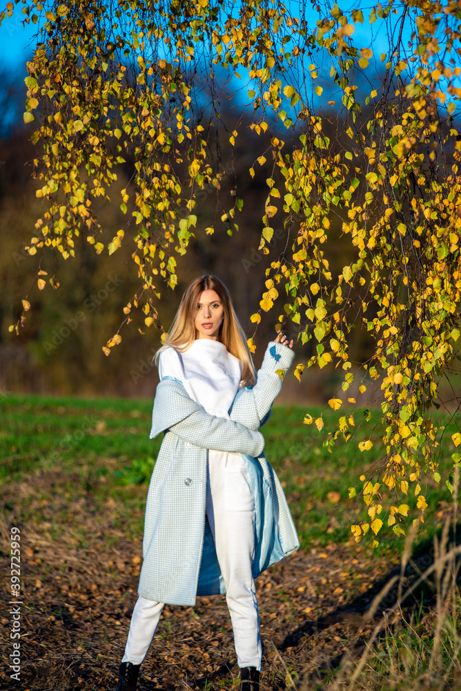 Beautiful woman in autumn clothes outdoor, blue sky background