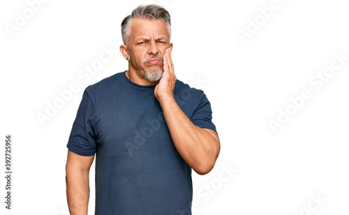 Middle age grey-haired man wearing casual clothes touching mouth with hand with painful expression because of toothache or dental illness on teeth. dentist