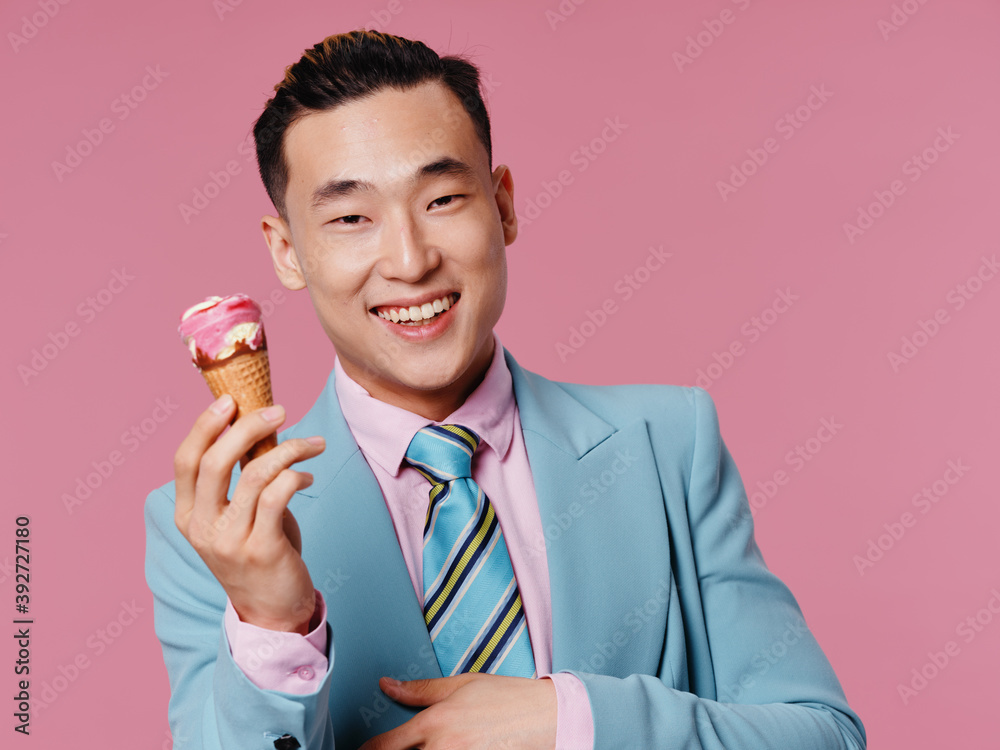 Cheerful man of Asian appearance ice cream in hands of joy cropped view of pink background Cheerful man of Asian appearance ice cream in hands of joy cropped view of pink background
