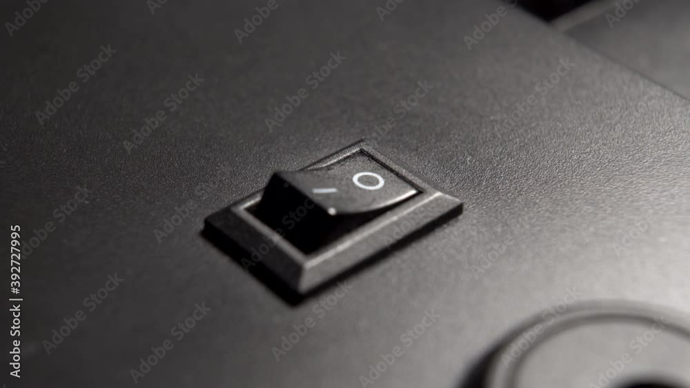 Switching the switch to the OFF position of an electrical appliance made of black plastic. Vintage scene. Macro shot. Close-up