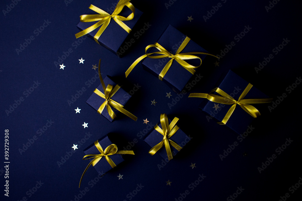 Navy blue gifts with gold ribbons.Set of gift box isolated on navy blue background.Christmas gift boxes on black background. Merry Christmas and Happy Holidays greeting card, frame, banner. 