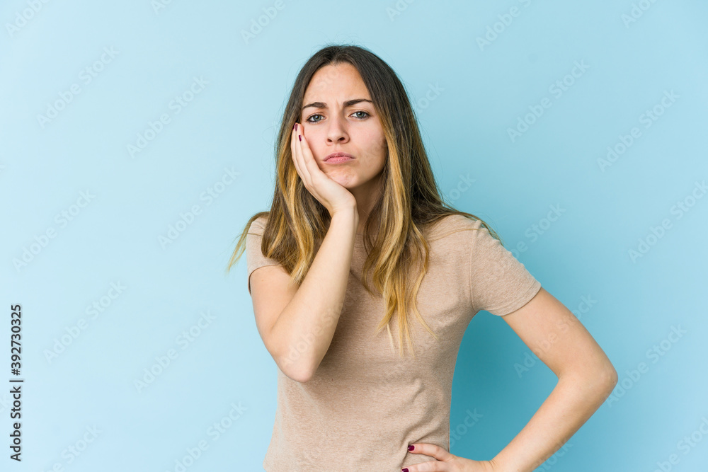 Young caucasian woman isolated on blue background who feels sad and pensive, looking at copy space. Young caucasian woman isolated on blue background who feels sad and pensive, looking at copy space.