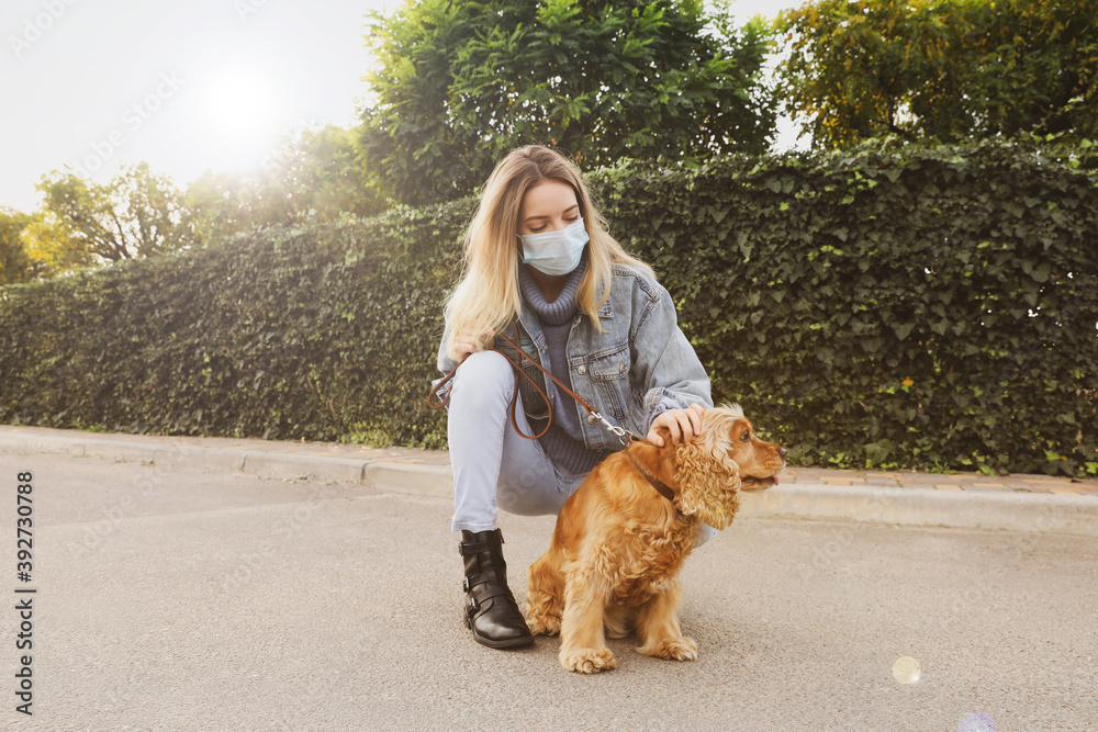 Woman in protective mask with English Cocker Spaniel outdoors. Walking dog during COVID-19 pandemic Woman in protective mask with English Cocker Spaniel outdoors. Walking dog during COVID-19 pandemic
