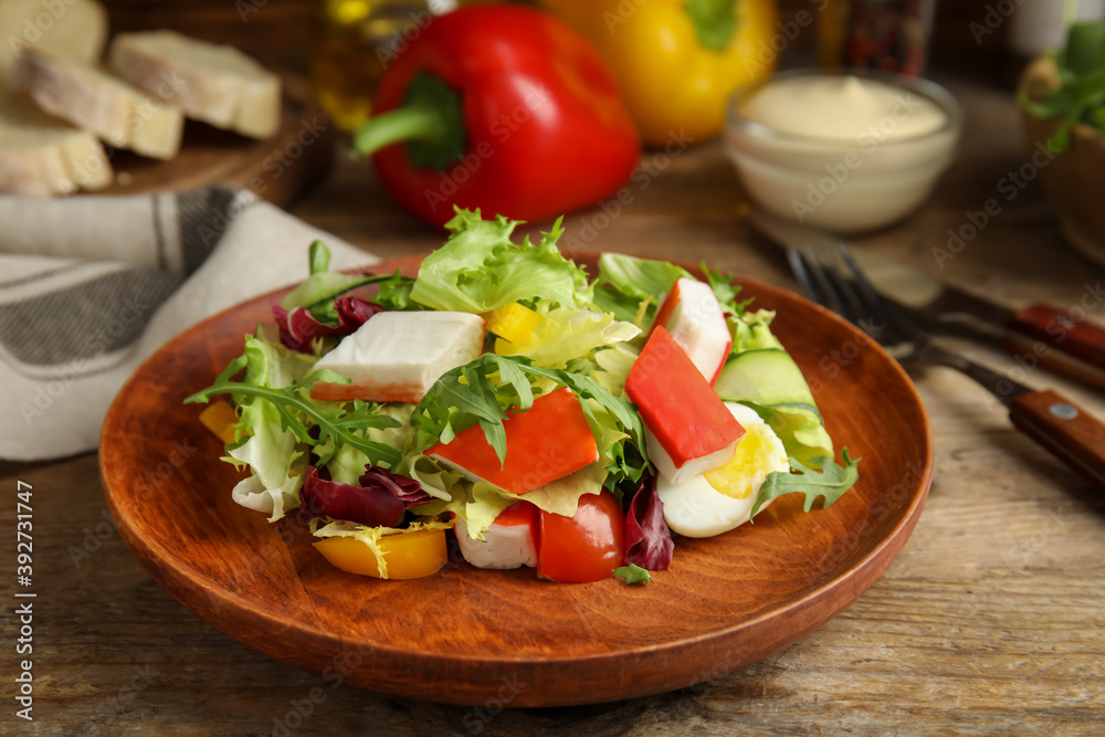 Delicious salad with crab sticks and lettuce on wooden table Delicious salad with crab sticks and lettuce on wooden table