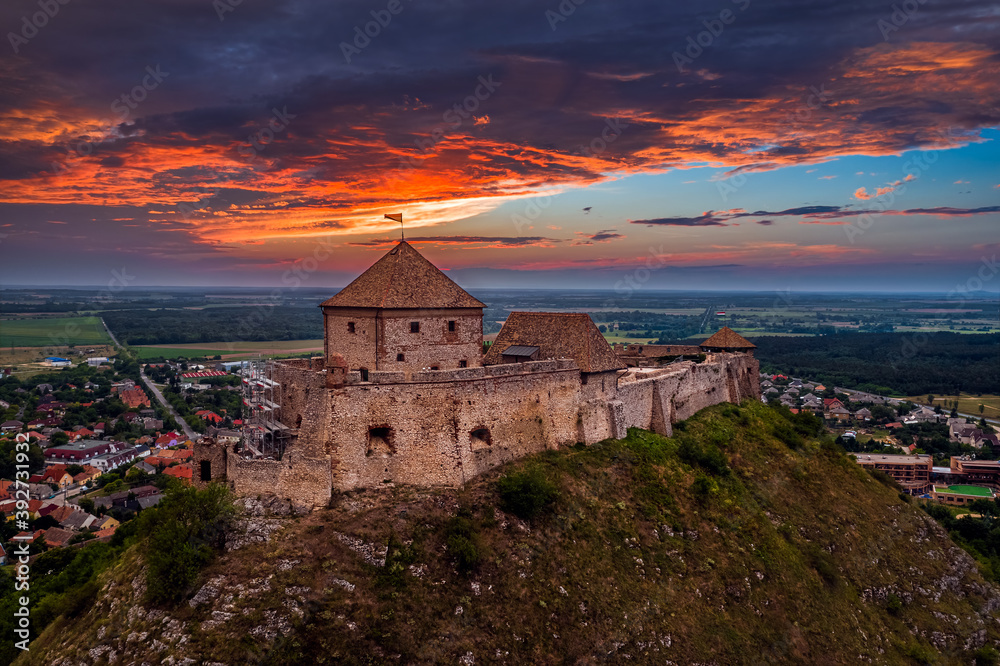 Sumeg, Hungary - Aerial panoramic view of the famous High Castle of Sumeg in Veszprem county at sunset with storm clouds and dramatic colors of sunset at background on a summer afternoon