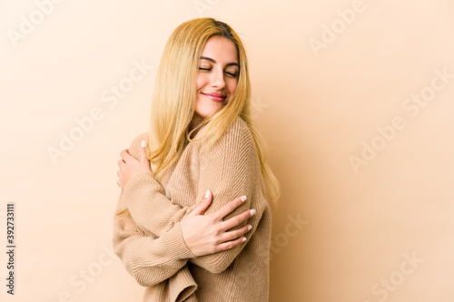 Young blonde caucasian woman hugs, smiling carefree and happy.