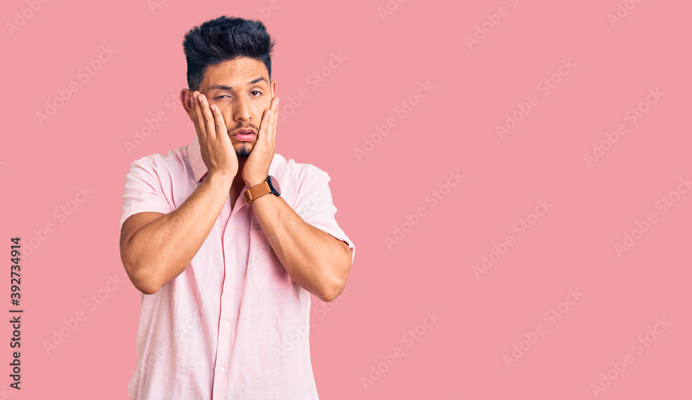 Handsome latin american young man wearing casual summer shirt tired hands covering face, depression and sadness, upset and irritated for problem