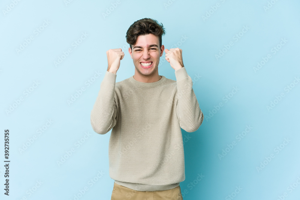 Young caucasian man isolated on blue background cheering carefree and excited. Victory concept. Young caucasian man isolated on blue background cheering carefree and excited. Victory concept.