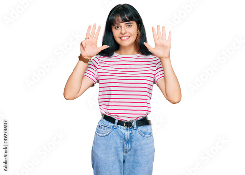 Young hispanic girl wearing casual clothes showing and pointing up with fingers number nine while smiling confident and happy.