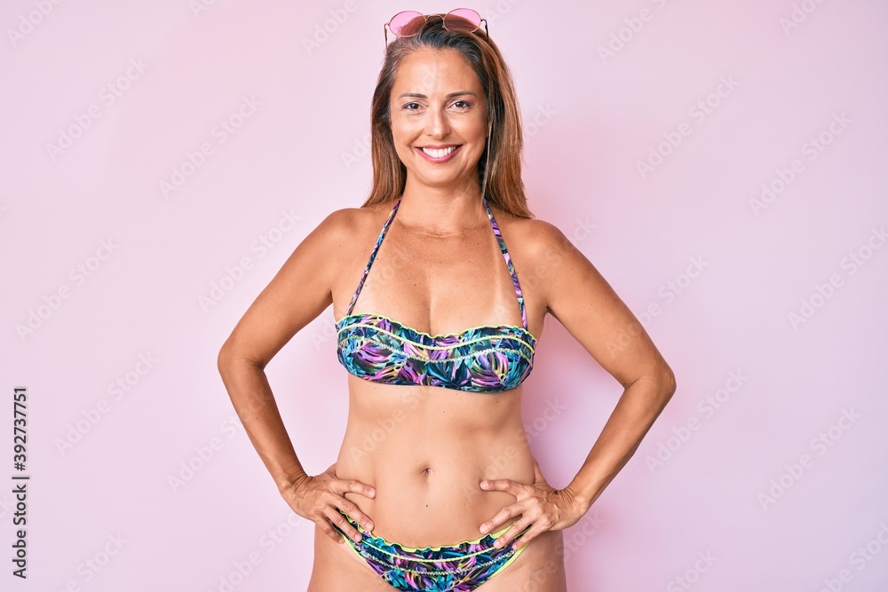 Fototapeta premium Middle age hispanic woman wearing bikini with a happy and cool smile on face. lucky person.