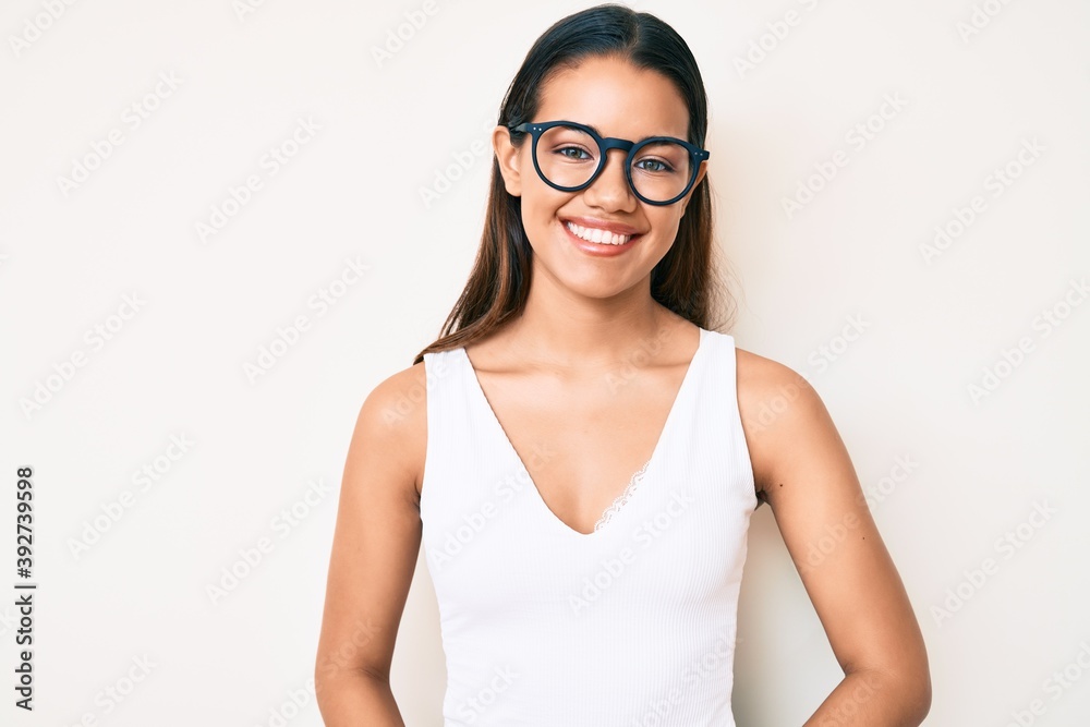 Young beautiful latin girl wearing casual clothes and glasses with a happy and cool smile on face. lucky person. Young beautiful latin girl wearing casual clothes and glasses with a happy and cool smile on face. lucky person.