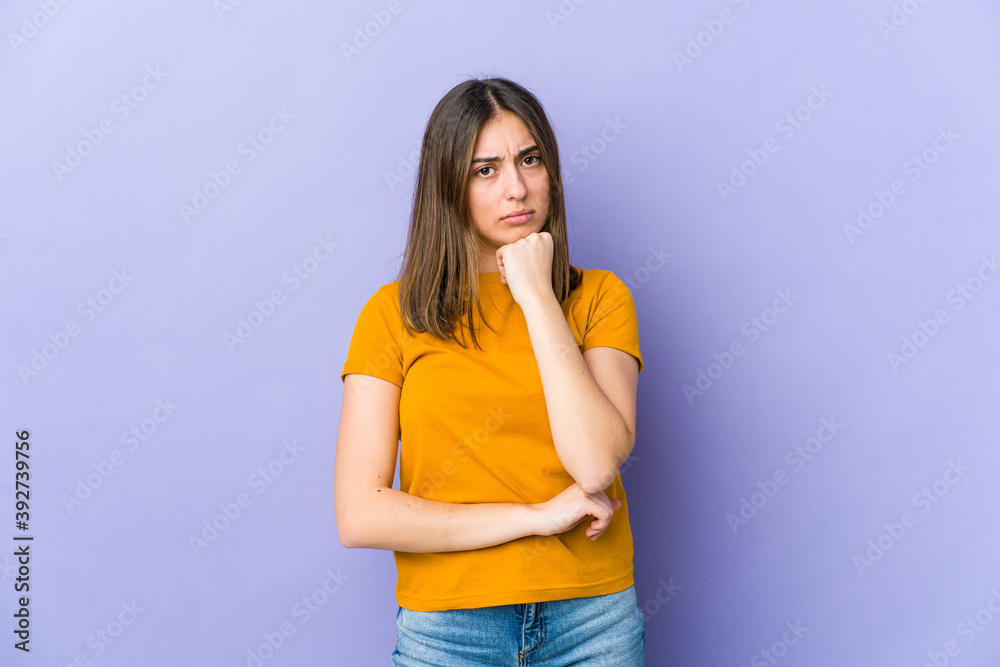 Young caucasian woman suspicious, uncertain, examining you.