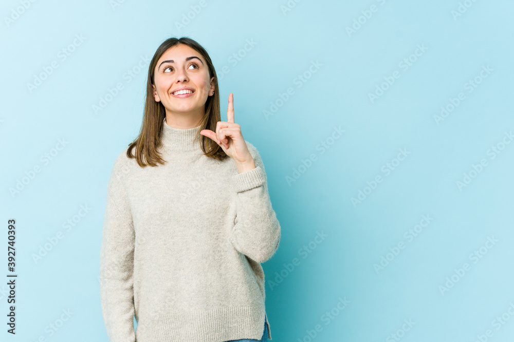 Young caucasian woman indicates with both fore fingers up showing a blank space. Young caucasian woman indicates with both fore fingers up showing a blank space.